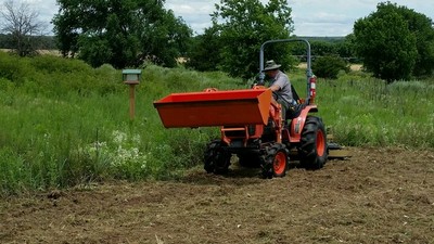 Park Rangers using a Kubota tractor to prepare the ground for planting seeds in the fall.