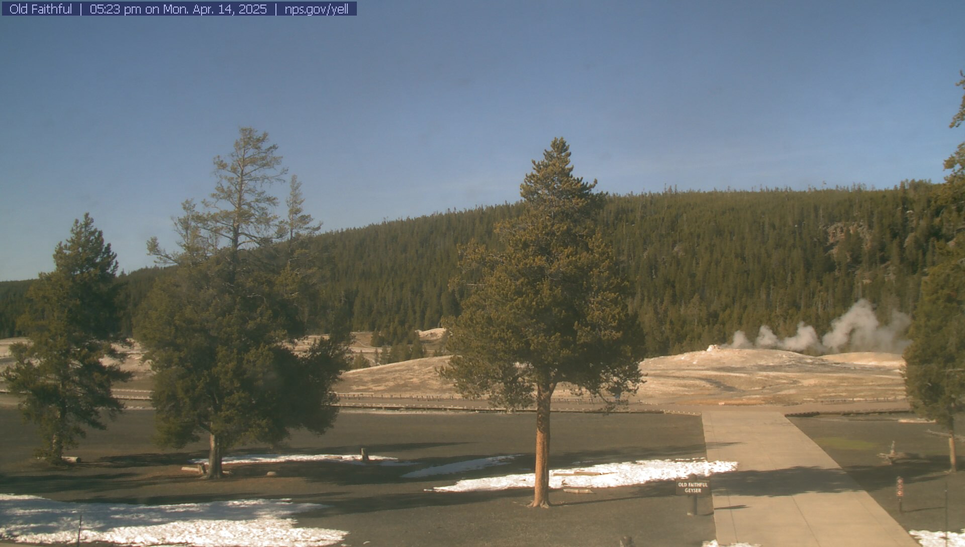 View of Old Faithful Geyser as seen through the front of the visitor education center.