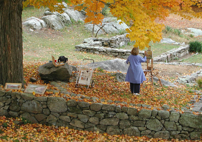 An artist paints among the terraced lawns and trees.