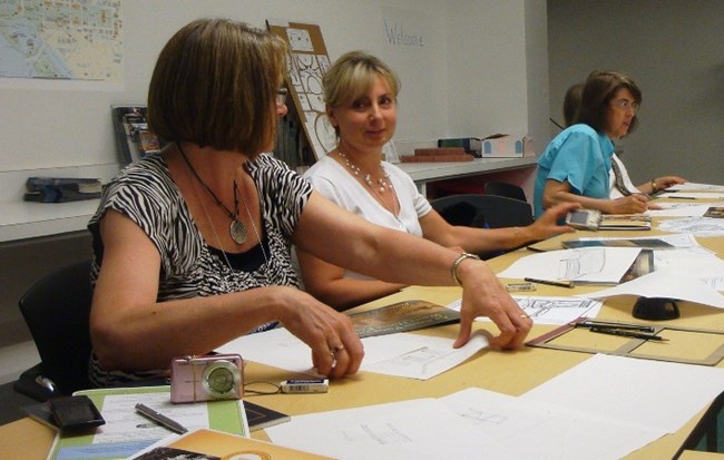 Image of three teachers working on a drawing during an teacher workshop at the White House Visitor Center.