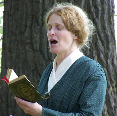 woman singing from hymn book