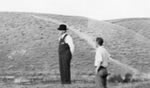 Black and white photo of men in overalls inspecting dry pond.