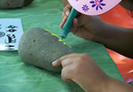 A young girl creates her own pictograph during a park craft activity.