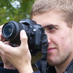 photographer looking through lens of camera