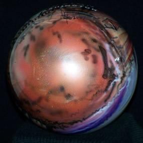 View of bottom of Christmas ornament which is red.