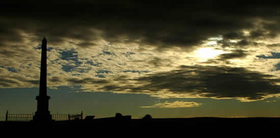 Memorial shaft makes striking silhouette against a dramatic sky.