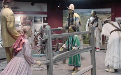 Mannequins representing the Whitmans and Cayuse face each other.