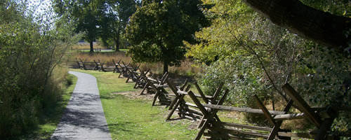 paved path along side split rail fence