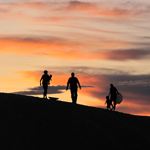 family enjoying the dunes at sunset