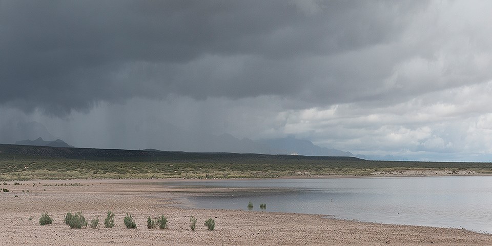 Water's edge under storm clouds
