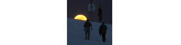 Visitors hiking under the full moon.