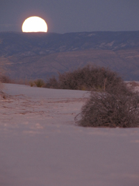 full moon rising over the dunes