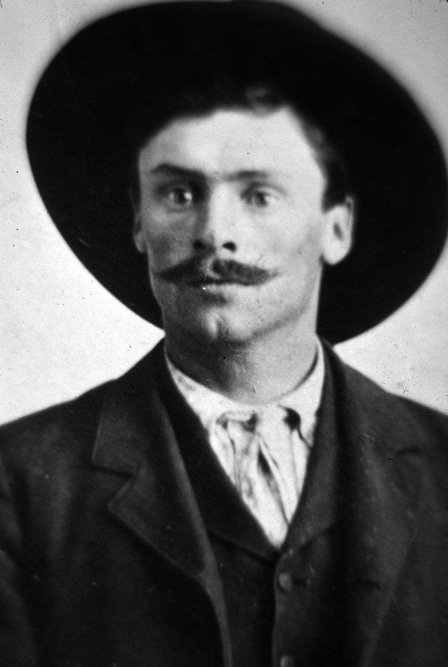 black and white portrait of a young man with a mustache and a wide brimmed hat