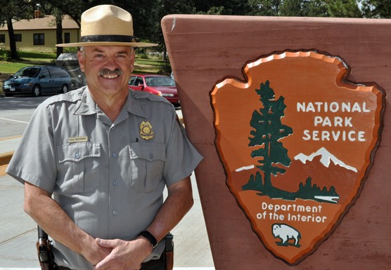 Chief Ranger Rick Mossman standing by Wind Cave National Park sign.