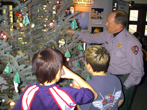 Ranger helping children decorate Christmas Tree