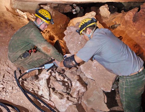 Two park employees installing new lights in Wind Cave