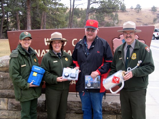 Displaying examples of equipment bought with grant money are, left to right, Supervisory Forestry Technician Sabrina Henry, Park Superintendent Linda L. Stoll, Pringle Fire Chief Bob Whitney, and Chief Ranger Rick Mossman.
