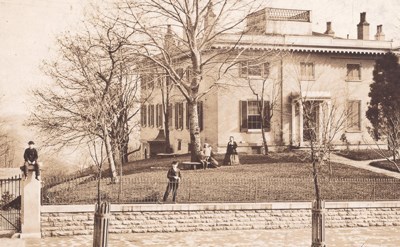 Old photo of the Taft house with people in the yard