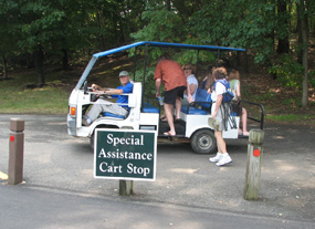 Patrons getting on a cart in the parking lot for a ride to the main gate.