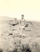 A CCC worker standing in front of Wupatki Pueblo