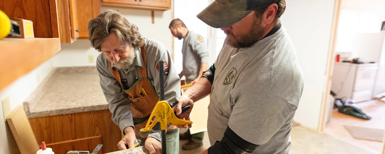 Carpenters installing a new countertop Two men hold a vice while installing a new countertop.