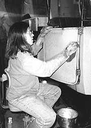 (YELL 106386-1) Museum Technician Kirk Dietz performing preventative conservation treatment on one of the White Motor Company service trucks. On motorized vehicles, this process includes extensive cleaning, degreasing, lubricating and protecting the entire vehicle.