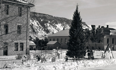 Though a bit later than the 1899 celebration described, this photo shows that ensuring local children had a merry Christmas continued for the next 100 years. Tree and decorations outside of the Administration Building in Mammoth, ca. 1960? Photo: #YELL 19967