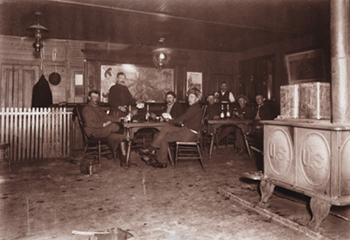 Soldiers relaxing with cards and drinks in the post exchange, Fort Yellowstone, Wyoming, circa 1900. Yellowstone Park Museum Collection, YELL 36921