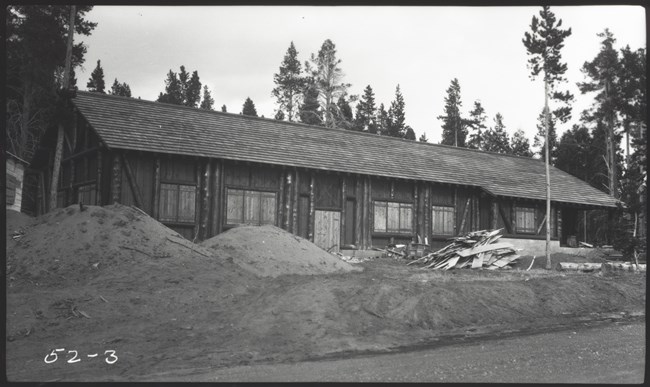newly constructed wooden building with construction debris piles