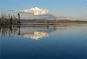 Yellowstone Lake with the sky and clouds reflected in the lake.