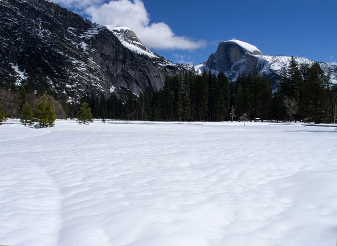 Half Dome and Yosemite Valley covered in white, fluffy snow.