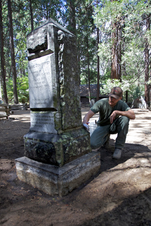Volunteer cleans lichens and mosses from the headstone of Sadie Schaeffer, a local waitress who drowned in the Merced River in 1901.