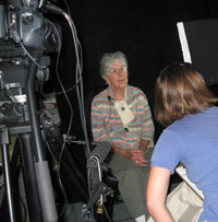 Woman sits in front of camera being interviewed