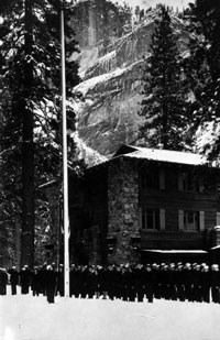 WWII soldiers stand outside the Ahwahnee in snow by a flagpole