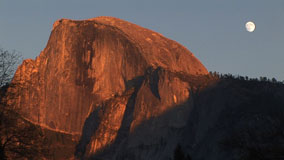 Sunset colors on Half Dome with moon in background