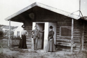 Historic photo of Judge Wickersham, his wife and a friend in front of their cabin in Eagle, Alaska, circa 1900.