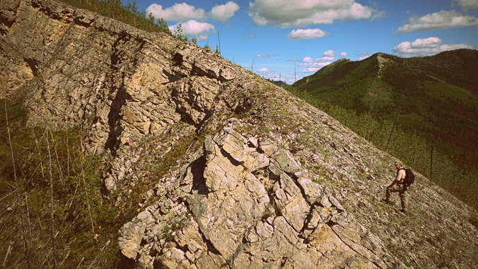 A hiker on a limestone bluff above the Yukon River