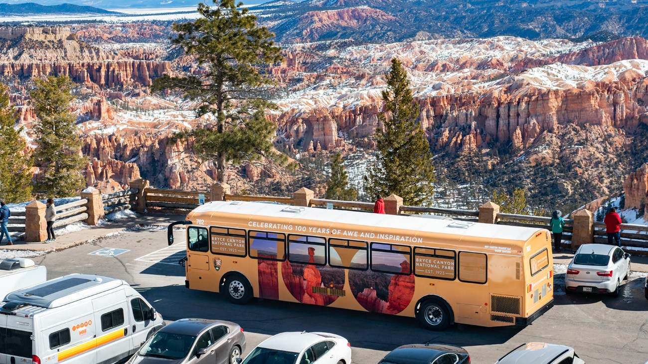 Cars in a parking lot with a shuttle in the background