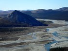 aerial view of a river flowing past low mountains