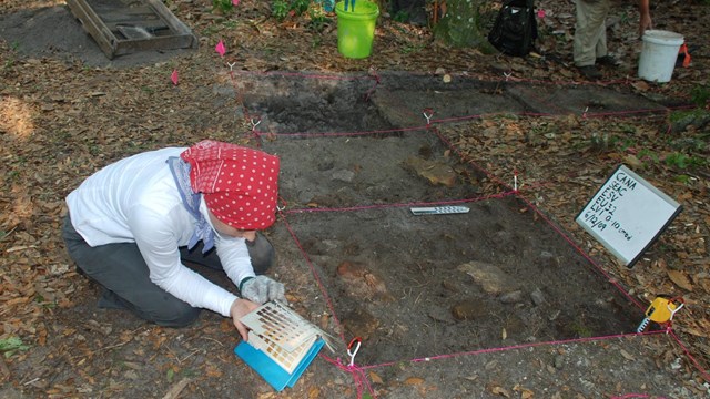 Volunteer using Munsell color book to record description of soil