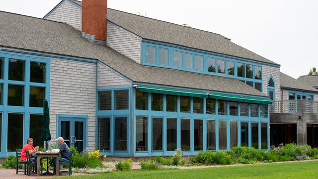 a blue building in front of green grass