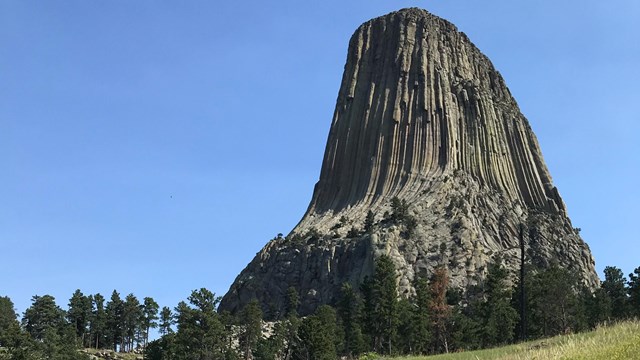 Sunny, blue sky with rock monolith in the distance 