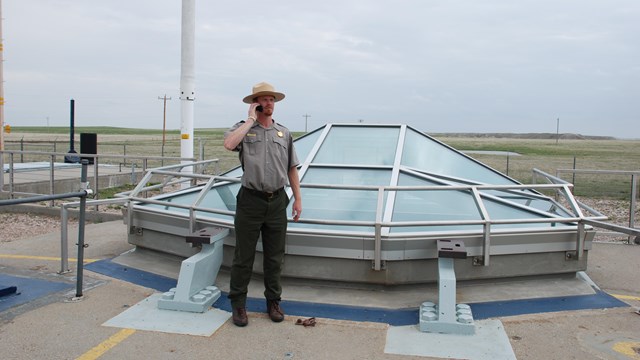 Ranger standing next to a missile silo listening to a tour on his cell phone