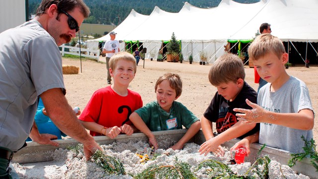 kids with a ranger playing in sand