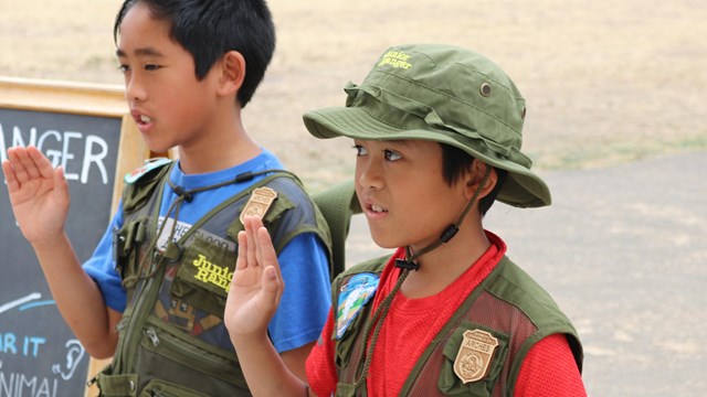 Two boy saying a pledge.