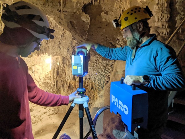 two people next to a tripod and a lidar scanner