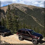 Two 4WD vehicles on a mountain pass road