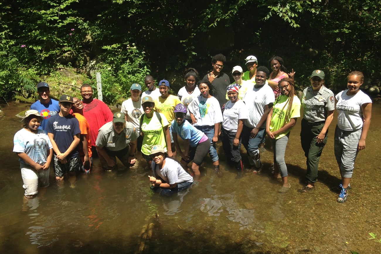 NPS employees and a team of high-school age people smiling at you