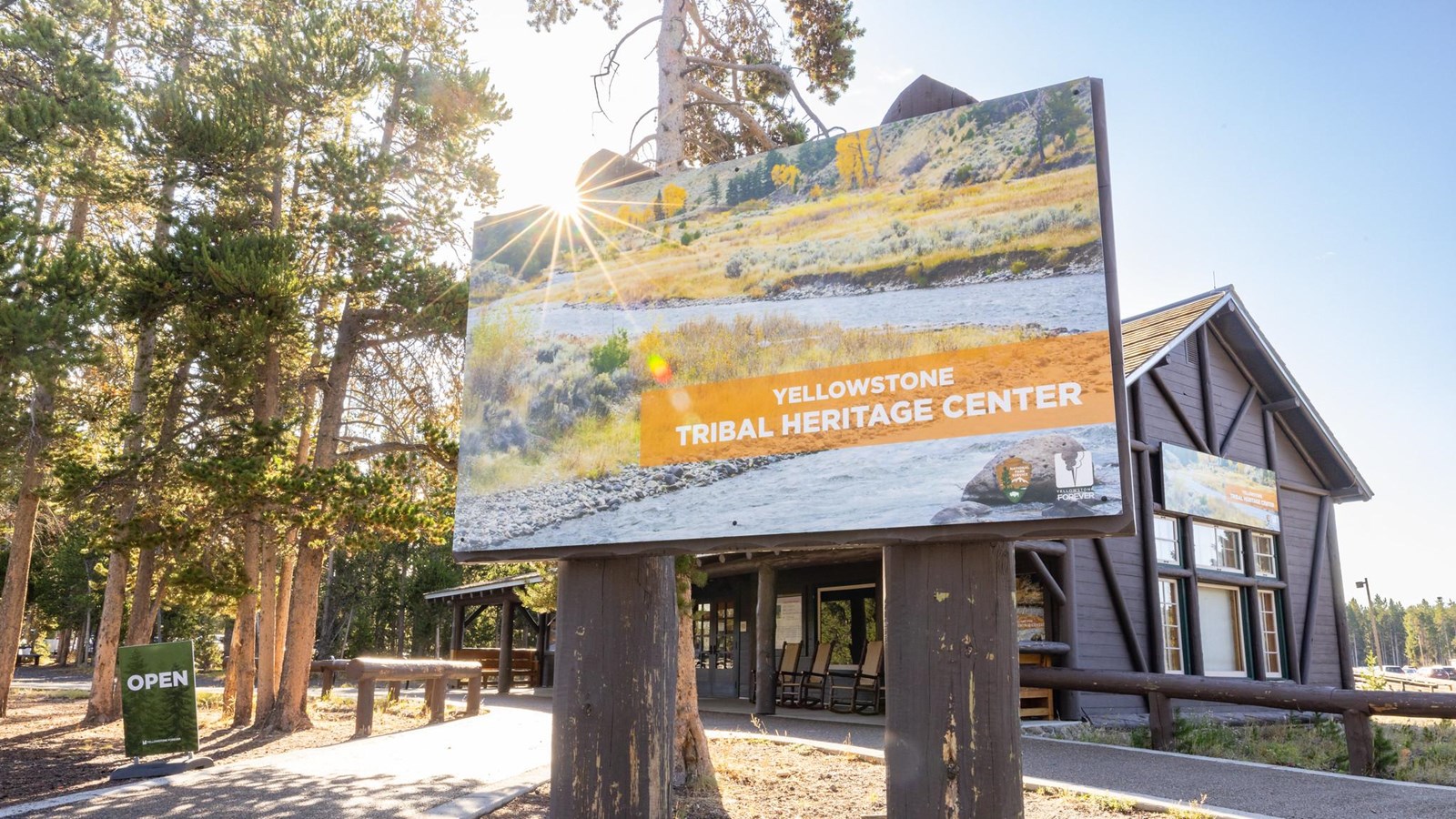 Sign that reads Yellowstone Tribal Heritage Center in front of rustic log building