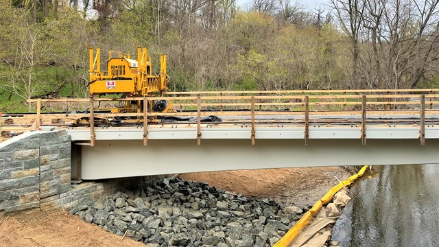 Large construction machinery on a trail's bridge